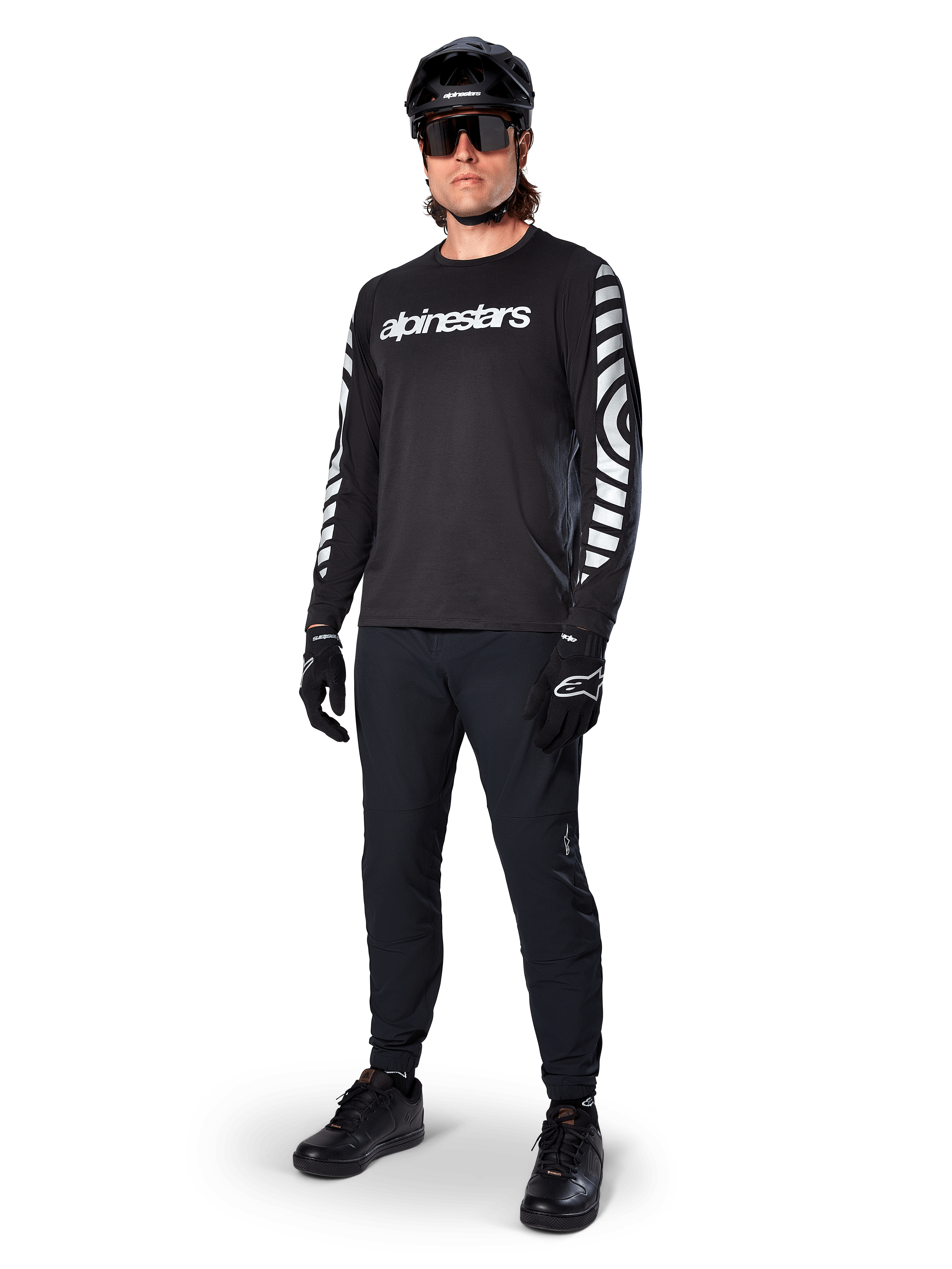 Alpinestars A-Dura Dri Oscar Long Sleeve Jersey, Black Reflective, featuring bold white Alpinestars wordmark on chest and reflective graphic patterns on the sleeves, worn with black mountain bike pants, helmet, and gloves, technical MTB apparel