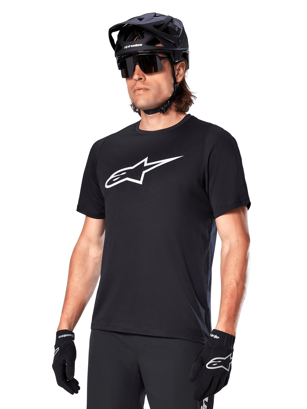Alpinestars A-Dura Dri Oscar Trikot, Kurzarm-MTB-Radtrikot, Schwarz mit weißem Logo, feuchtigkeitsableitendes Funktionsmaterial, getragen mit schwarzem Helm, Sonnenbrille und Handschuhen