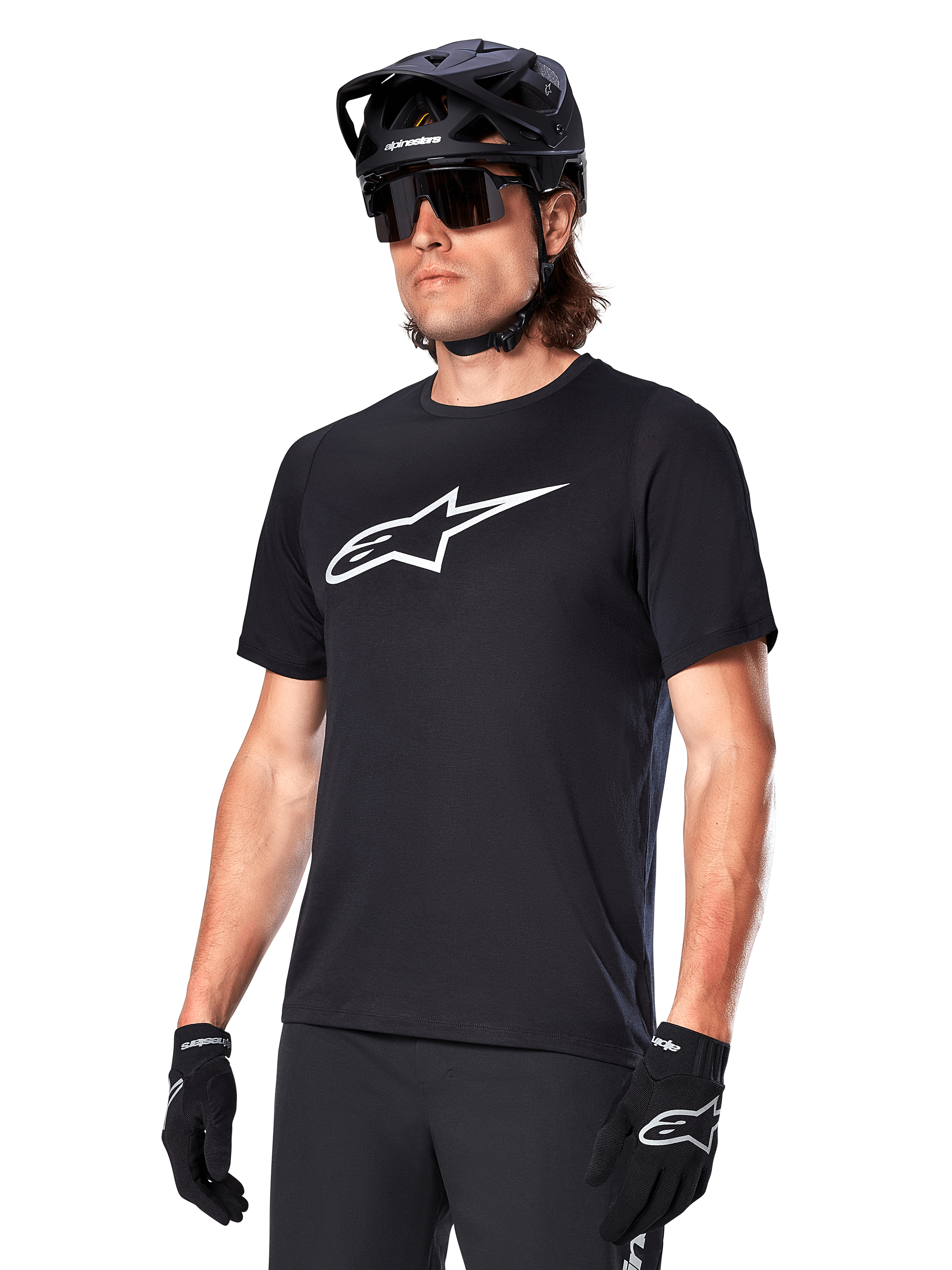 Alpinestars A-Dura Dri Oscar Trikot, Kurzarm-MTB-Radtrikot, Schwarz mit weißem Logo, feuchtigkeitsableitendes Funktionsmaterial, getragen mit schwarzem Helm, Sonnenbrille und Handschuhen