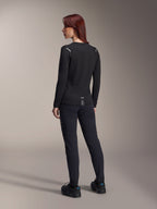 Alpinestars Stella A-Dura Thermal Jersey voor dames, MTB-shirt met lange mouwen in het zwart, achteraanzicht met reflecterende schouderaccenten en verlengde drop tail, gedragen met zwarte broek en schoenen, performance kleding voor mountainbiken
