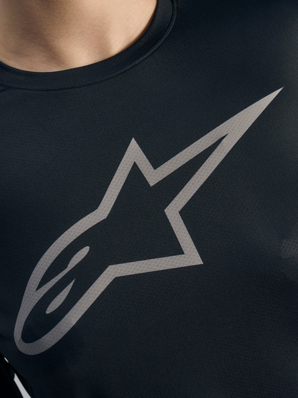 Logo Alpinestars gris sur maillot Stella A-Dura Ride noir, tissu jacquard VTT performant pour femme.