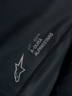 Détail du maillot Stella A-Dura Ride noir, tissu jacquard technique avec logos A-DURA ALPINESTARS et Astars.
