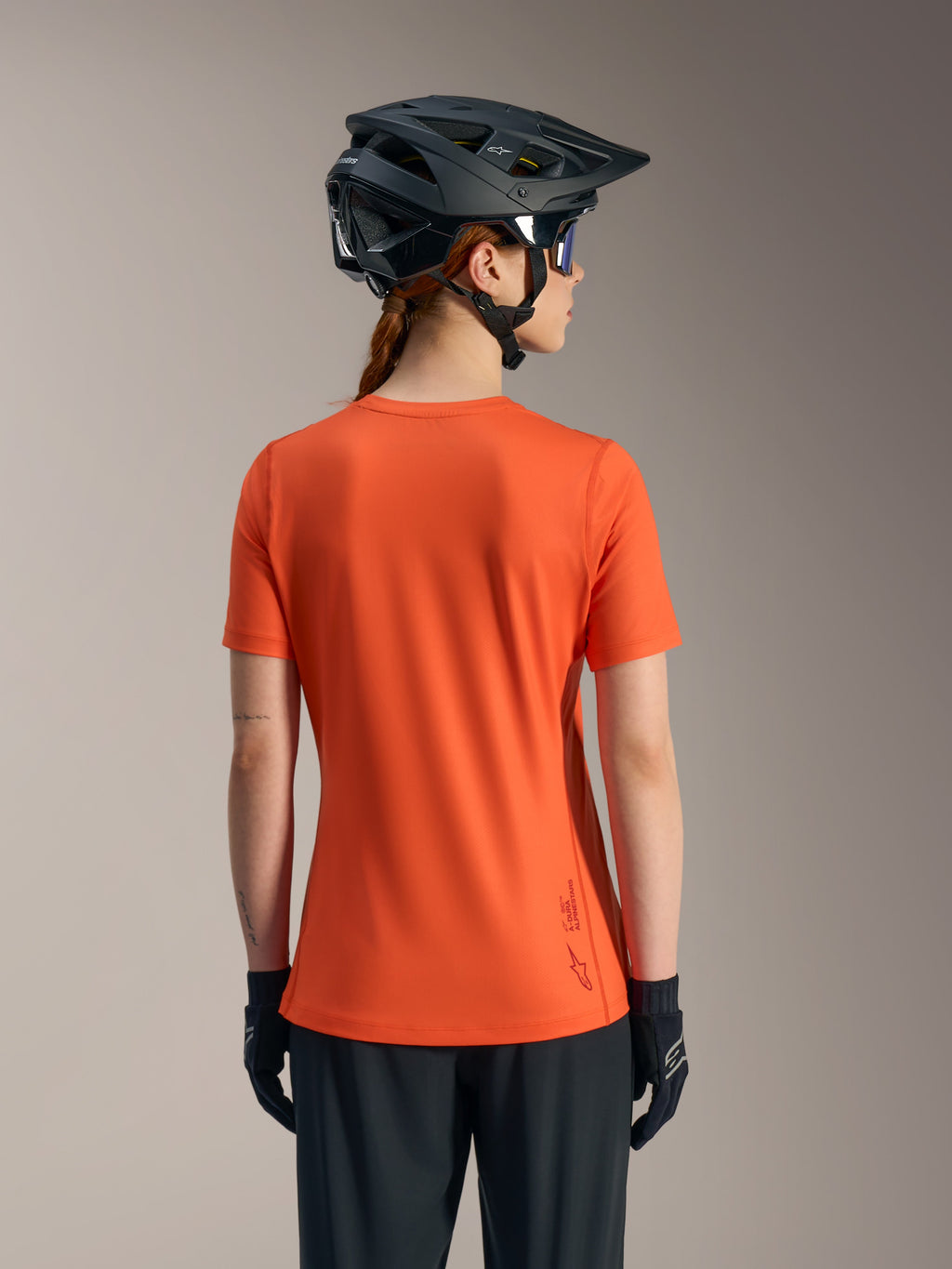 Maillot Stella A-Dura Ride orange, vue de dos du haut de VTT femme à manches courtes en tissu technique recyclé.