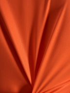 Détail du tissu jacquard orange du maillot Alpinestars Stella A-Dura Ride, texture légère et extensible.