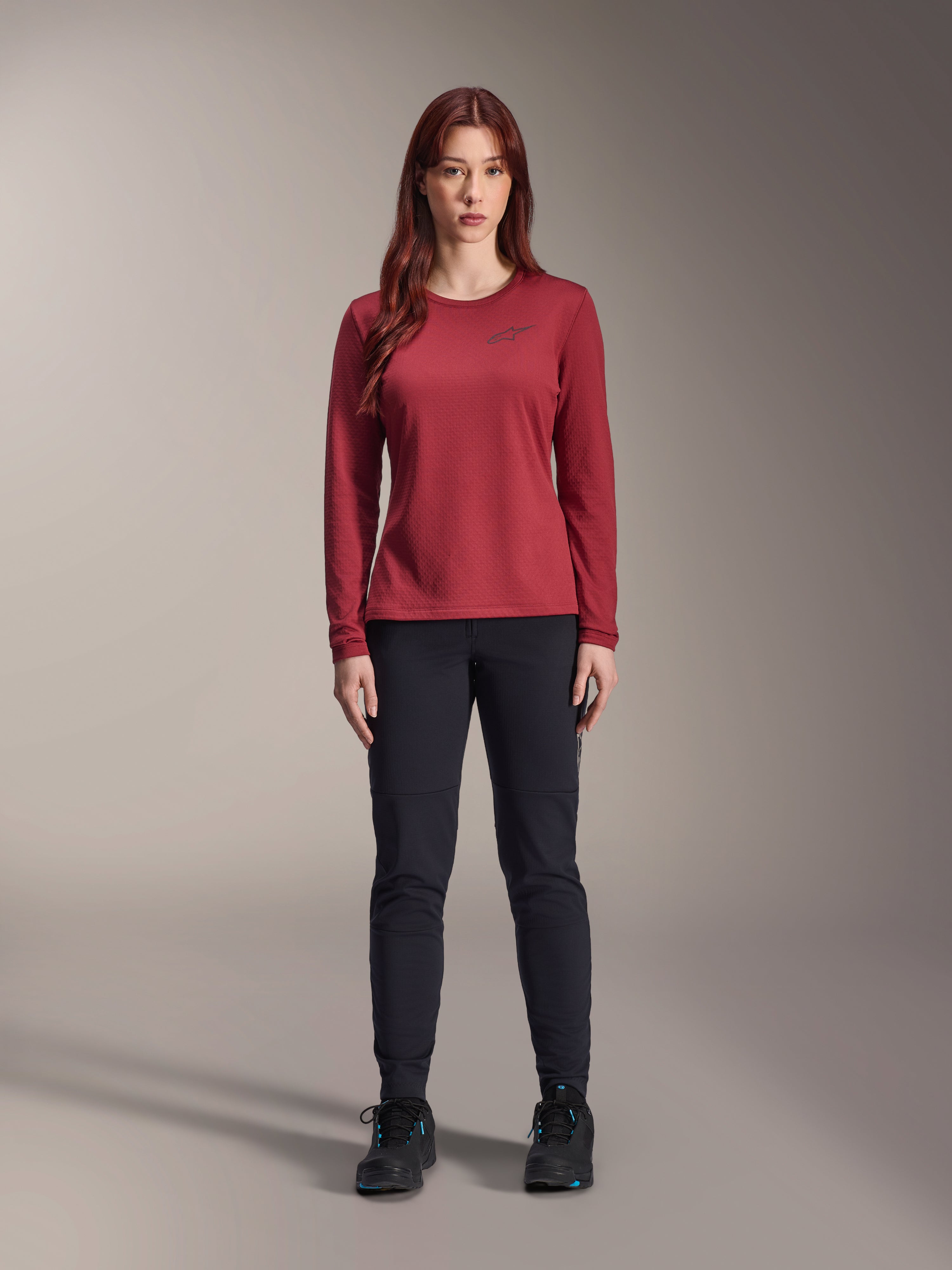 Alpinestars Stella A-Dura Thermal Pant, dames MTB-broek, zwart, gedragen met een bordeauxrode technische jersey met lange mouwen, slim-fit thermisch ontwerp voor fietsen in koud weer, duurzame buitenlaag met voering van geborsteld fleece