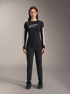 Frau im Alpinestars Stella A-Dura Dri Astar Langarmtrikot, Schwarz mit weißem Brustlogo und hellen Mesh-Ärmeleinsätzen, kombiniert mit schwarzer Hose und schwarzen Schuhen, technische Mountainbike-Bekleidung