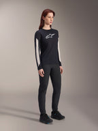 Alpinestars Stella A-Dura Dri Astar Langarmtrikot für Damen, Schwarz, mit weißen Mesh-Einsätzen an den Ärmeln und weißem Astar-Logo, getragen mit schwarzer Hose und Schuhen, technische Radsport-Funktionsbekleidung für Mountainbiking
