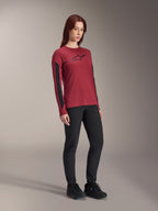 Maillot à manches longues Alpinestars Stella A-Dura Dri Astar pour femme, rouge bordeaux avec logo noir sur la poitrine et empiècements en maille noire sur les manches, porté avec un pantalon technique noir et des chaussures de vélo noires, vêtement de VTT haute performance pour femme