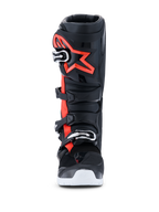 Alpinestars 2026 Tech 7 Enduro Drystar® laarzen, motocross- en enduro-laarzen, zwart, rood fluo en wit, vooraanzicht, voorzien van een sluitingssysteem met vier gespen, versterkte TPU-scheenplaat met een groot rood Alpinestars-logo en witte buitenzool, ontworpen voor waterdichte off-road prestaties.