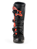 Bottes Alpinestars Tech 7, bottes de motocross, noir et rouge fluo, vue de face, avec un grand logo étoile Alpinestars rouge fluo sur la plaque tibiale, système de fermeture à quatre boucles et construction en TPU durable conçue pour la course tout-terrain