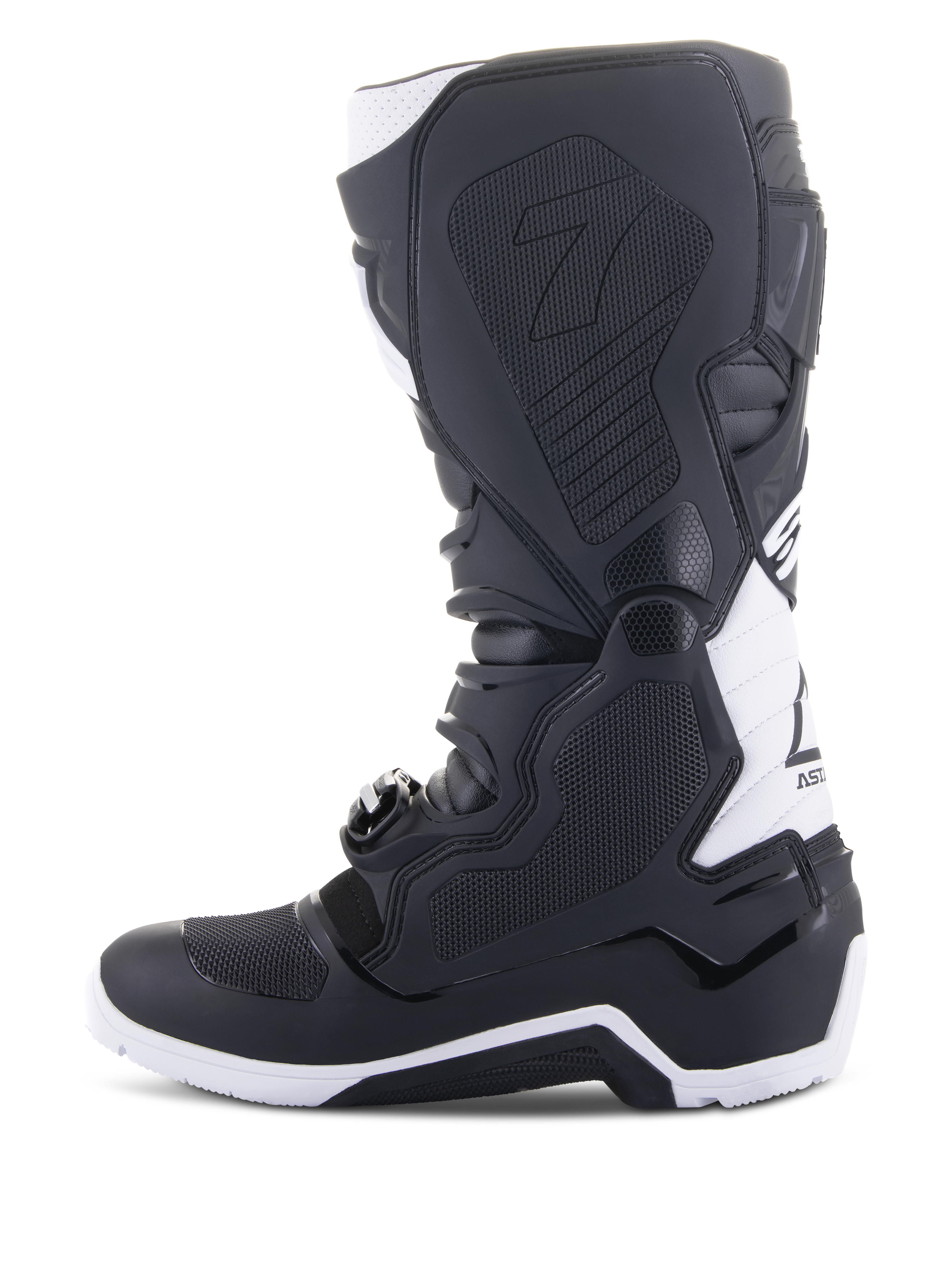 Alpinestars Tech 7 Enduro Drystar® laarzen, enduro motorlaarzen, zwart en wit, zijaanzicht van de mediale zijde met grippanelen met honingraatstructuur, TPU-constructie en witte accenten op de hiel en kuit, professioneel off-road schoeisel