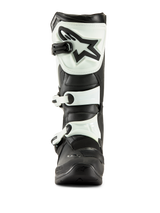 Bottes Alpinestars Tech 3, bottes de motocross, noir et blanc, vue de face montrant la plaque tibiale en TPU blanc avec logo étoile noir et sangles à boucles blanches, équipement tout-terrain durable