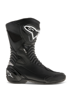 Alpinestars SMX S Stiefel, Motorradrennstiefel, Schwarz mit weißen Logos, Seitenansicht mit strapazierfähiger Mikrofaser-Konstruktion, verstärktem Schienbein- und Fersenschutz, flexiblen Akkordeon-Flexzonen und einem schlanken aerodynamischen Design für sportliches Fahren.