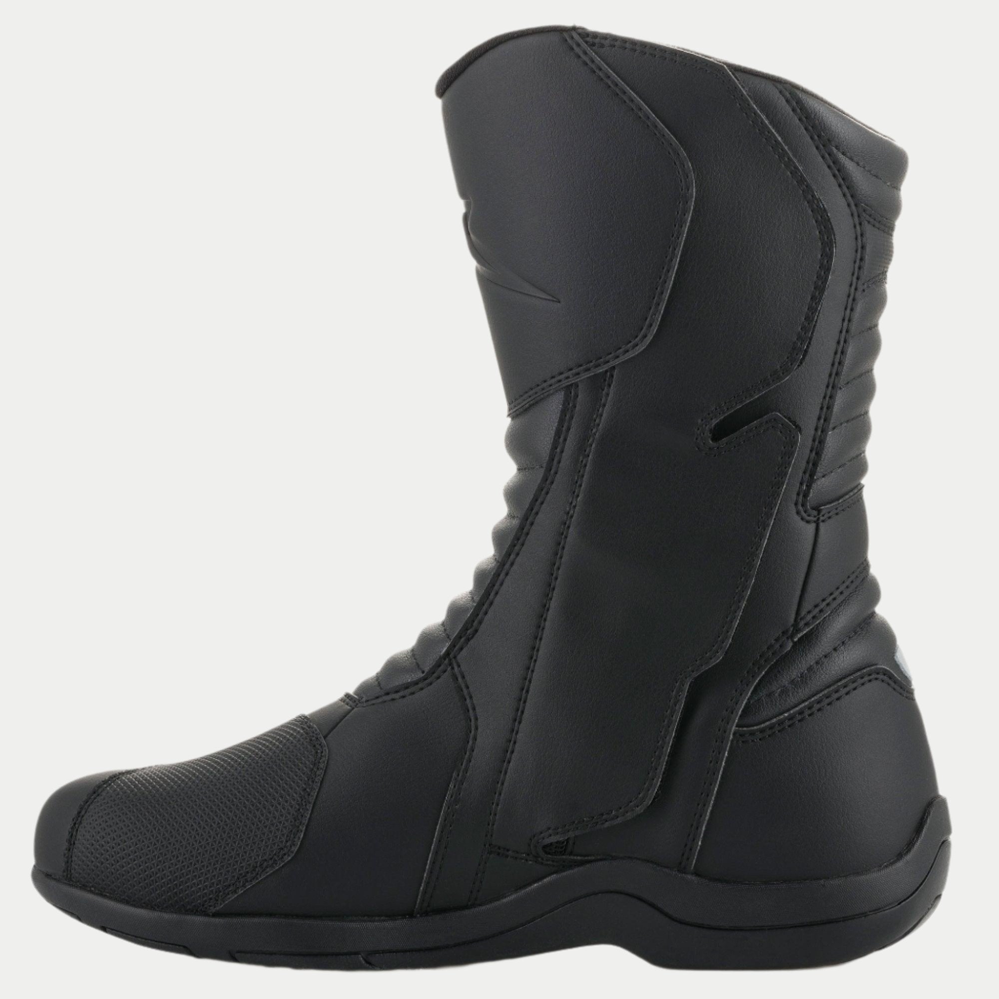 Bottes Alpinestars Origin Drystar®, bottes de moto touring noires, vue de profil du côté médial montrant le rabat du système d'ouverture, tige en microfibre avec zones de flexion en accordéon à l'avant et à l'arrière, conception imperméable durable pour la route et l'aventure