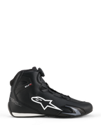 Chaussures Alpinestars Celer, chaussures de moto, noir et blanc, profil latéral avec grand logo étoile blanc, molette du système de fermeture Rotor pour l'ajustement, et silhouette sportive élégante axée sur la performance