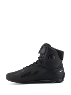 Chaussures Alpinestars Faster-4, chaussures de moto, noires, vue de profil, design montant avec fermeture à lacets et sangle supérieure réglable, texte « Alpinestars Protects » sur le côté latéral, tige en microfibre épurée avec zones de protection intégrées