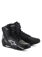 Chaussures Alpinestars Faster-4, chaussures de moto noires avec détails blancs, coupe mi-haute avec logo Astars blanc, inscription « Alpinestars Protects » sur l'avant, fermeture à lacets et bande auto-agrippante.