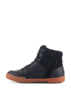 Chaussures Alpinestars Chrome Drystar®, Noir Noir Gomme, chaussures de moto urbaines avec tige en cuir noir et daim, profil montant style basket, semelle en caoutchouc couleur gomme et fermeture éclair latérale.