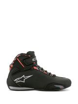 Chaussures imperméables Alpinestars Sektor, chaussures de moto, noir, gris foncé et rouge fluo, profil latéral avec lacets et sangle Velcro, logo blanc et accents de style camouflage rouge sur le col de la cheville.