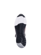Chaussures de moto Alpinestars CR-X Drystar® pour femme, vue de dessous de la semelle extérieure, avec le marquage TPF Transversal Protection Frame sur la pointe blanche, un motif de semelle multidirectionnel noir et un talon gris avec logo étoilé.