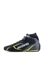 Chaussures Alpinestars Tech-1 T V3 FIA, chaussures de course automobile, noir, gris froid et jaune fluo, vue de profil montrant la construction en cuir, logo ASTARS blanc, col élastique ignifuge et touches de jaune vif.
