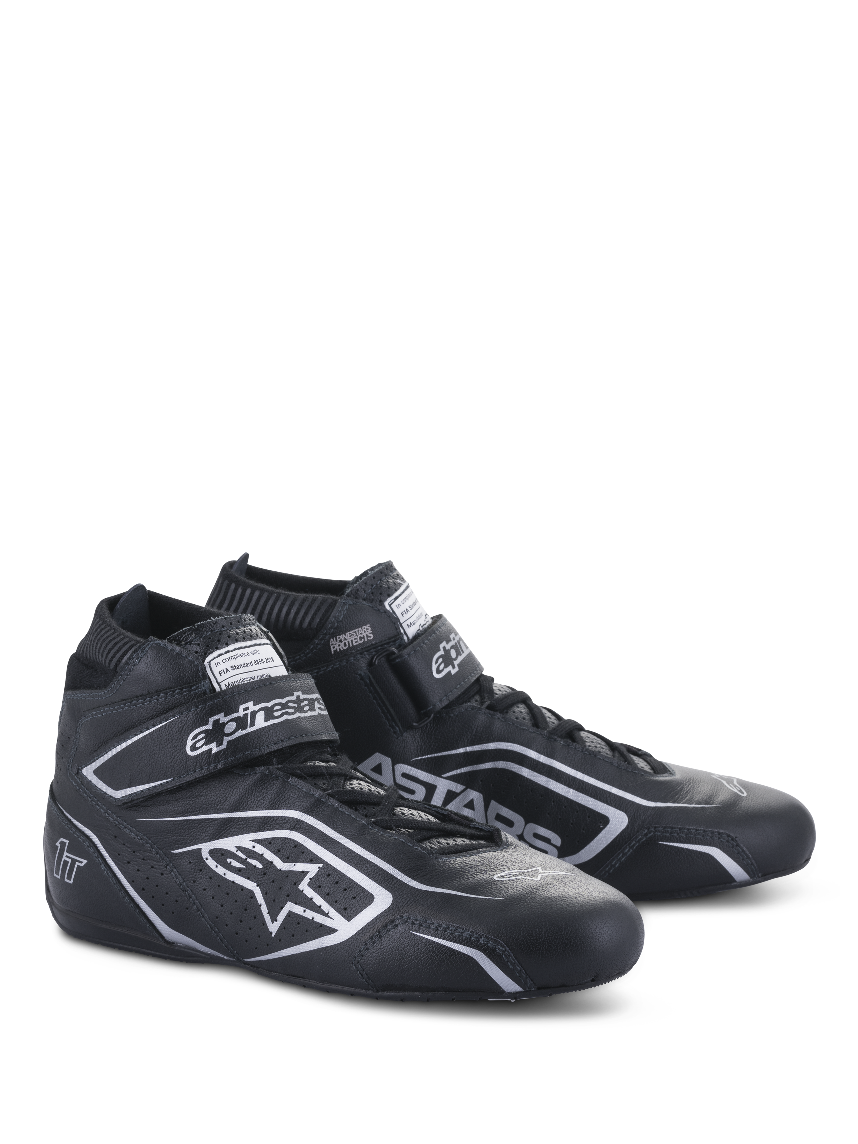 Chaussures Alpinestars Tech-1 T V3 FIA, chaussures de course automobile, noir et argent, construction en cuir de bovin avec logos et marquages Alpinestars argentés, vue latérale inclinée avec sangle auto-agrippante et fermeture à lacets