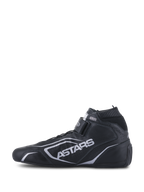 Alpinestars Tech-1 T V3 Shoes FIA, chaussures de course automobile, noir et argent, vue de profil, construction intégrale en cuir de bovin avec logo ASTARS argenté, sangle à crochet et boucle réglable et col élastique ignifuge.