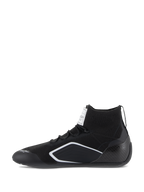 Chaussures Alpinestars Supertech, chaussures de course automobile, noires, vue de profil avec tige en tricot, contrefort de talon en fibre de carbone et accents géométriques blancs, équipement professionnel de sport automobile