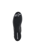 Chaussures Alpinestars Supertech, chaussures de course automobile, noires, vue de dessous de la semelle extérieure en caoutchouc ultra-fine avec logo étoile blanc et inscription Alpinestars, présentant un motif de bande de roulement asymétrique pour la sensibilité aux pédales et l'adhérence