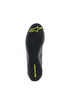 Chaussures Alpinestars Supertech, chaussures de course automobile, gris et jaune fluo, vue détaillée de la semelle extérieure en caoutchouc noir avec bande de roulement asymétrique texturée et logos Alpinestars jaunes pour l'adhérence aux pédales et la sensibilité.