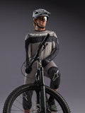 Grijze Alpinestars A-Dura Race jersey met lange mouwen op een MTB-rijder, met zwarte accenten en professionele gear.