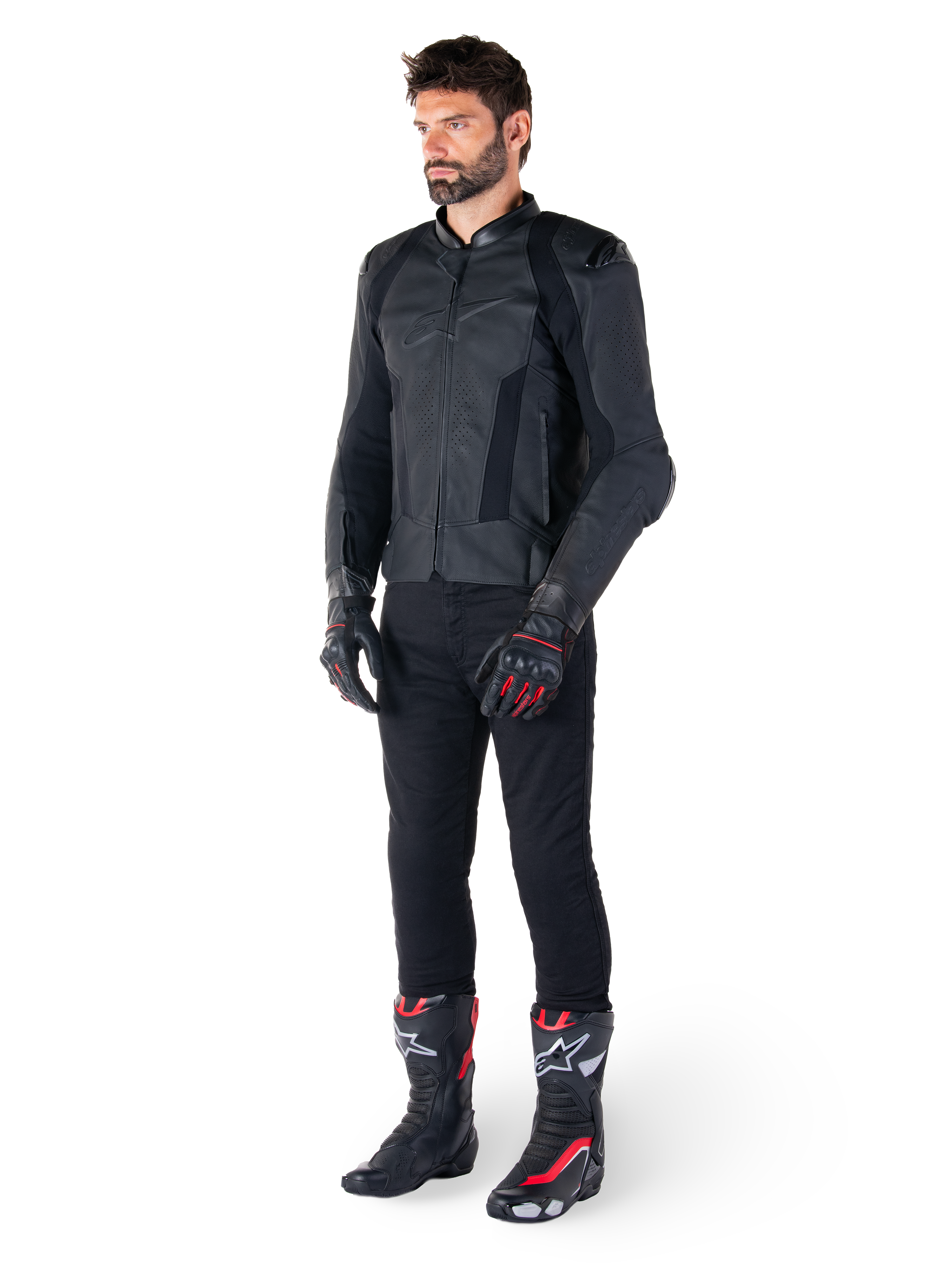 Veste en cuir Alpinestars Missile V3, noire, portée par un pilote avec un pantalon noir et des gants et bottes de course noirs et rouges, dotée de panneaux en cuir perforé et d'un logo monochrome élégant, esthétique sportive professionnelle