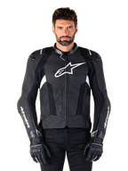 Blouson en cuir Alpinestars Missile V3, noir avec logos blancs, porté par un mannequin avec des gants de moto noirs, veste de course en cuir premium avec panneaux de ventilation perforés et caractéristiques de performance
