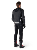 Veste en cuir Alpinestars Missile V3, noir et blanc, vue arrière sur le pilote, avec logo Alpinestars blanc imposant en bas du dos et petit logo sur le haut du dos, portée avec un pantalon noir et des bottes de course, conception en cuir premium pour la course moto