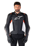 Alpinestars Missile V3 leren jas, zwart, wit en rood fluo, premium racing sportjas van rundleer, wit logo op de borst en Alpinestars-branding op de mouwen, gedragen met zwarte motorhandschoenen en broek