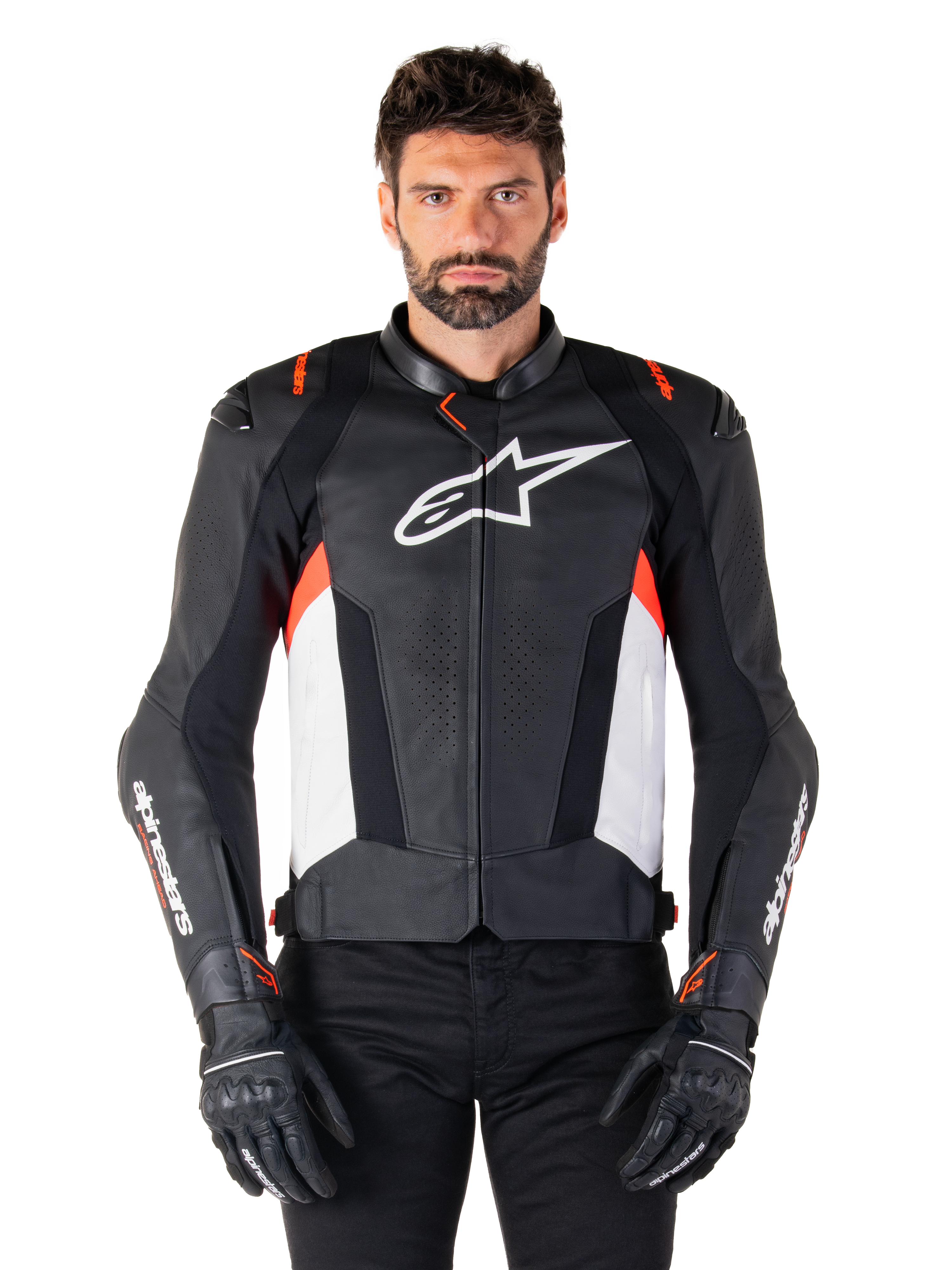 Alpinestars Missile V3 leren jas, zwart, wit en rood fluo, premium racing sportjas van rundleer, wit logo op de borst en Alpinestars-branding op de mouwen, gedragen met zwarte motorhandschoenen en broek