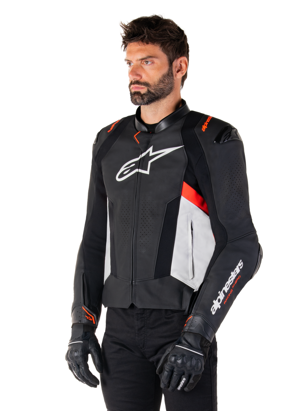 Alpinestars Missile V3 Leren Jas, zwart, wit en rood fluo, racing sport motorjas gedragen door een model met zwarte handschoenen en broek, voorzien van geperforeerde leren panelen en opvallende Alpinestars-branding