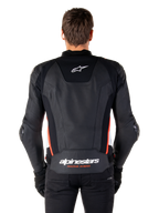 Alpinestars Missile V3 Leren Jas, achteraanzicht, premium zwart leer met rood fluo en witte accenten, met een wit ster-logo op de bovenrug en Alpinestars-branding op de onderrug, gedragen met een zwarte broek en handschoenen.