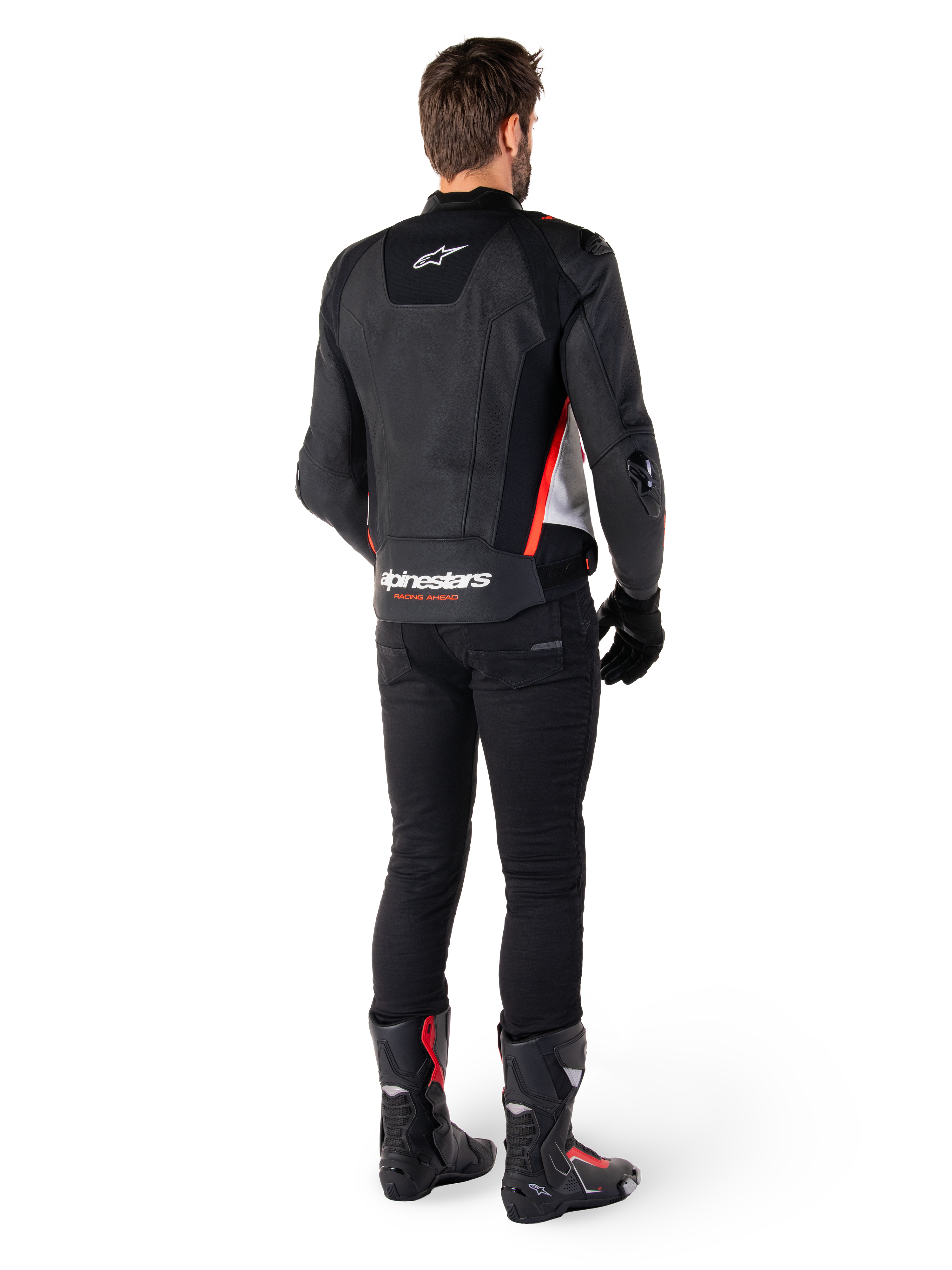 Alpinestars Missile V3 Leren Jas in Zwart Wit Rood Fluo, achteraanzicht op een mannelijke rijder, met Alpinestars-branding op de boven- en onderrug, gecombineerd met een zwarte broek en motorlaarzen, op racen geïnspireerde leren sportjas