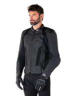 Alpinestars Missile V3 Airflow Lederjacke, Schwarz, getragen von einem Mann mit schwarzen Motorradhandschuhen und -hosen, mit umfangreichen perforierten Ledereinsätzen, DFS-Schulterprotektoren und sportlichem Race-Fit-Design.
