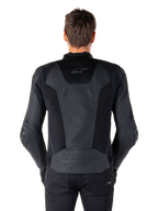 Rückansicht eines Models in der Alpinestars Missile V3 Airflow Lederjacke in Schwarz; zeigt umfangreiche perforierte Paneele und Mesh-Einsätze am Rücken zur Belüftung sowie ein geprägtes Branding am unteren Rücken.