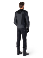 Rückansicht eines Mannes in der Alpinestars Missile V3 Airflow Lederjacke in Schwarz, mit großflächigen perforierten Einsätzen zur Belüftung, kombiniert mit schwarzer Motorradhose und Stiefeln, eine stromlinienförmige Rennsport-Ästhetik präsentierend.