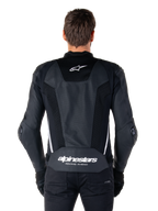 Alpinestars Missile V3 Airflow Lederjacke, Schwarz und Weiß, Rückansicht am Fahrer, mit umfassenden perforierten Ledereinsätzen, weißen Seitenakzenten, Alpinestars Stern-Logo auf dem oberen Rücken und 'alpinestars RACING AHEAD'-Branding am unteren Rücken.