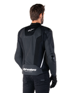 Alpinestars Missile V3 Airflow Lederjacke, Schwarz und Weiß, Rückansicht mit perforiertem Leder und Mesh-Einsätzen für maximale Belüftung, weißes Alpinestars-Branding am unteren Rücken und Stern-Logo am Nacken, getragen mit schwarzer Fahrausrüstung, Premium-Rennsport-Design.