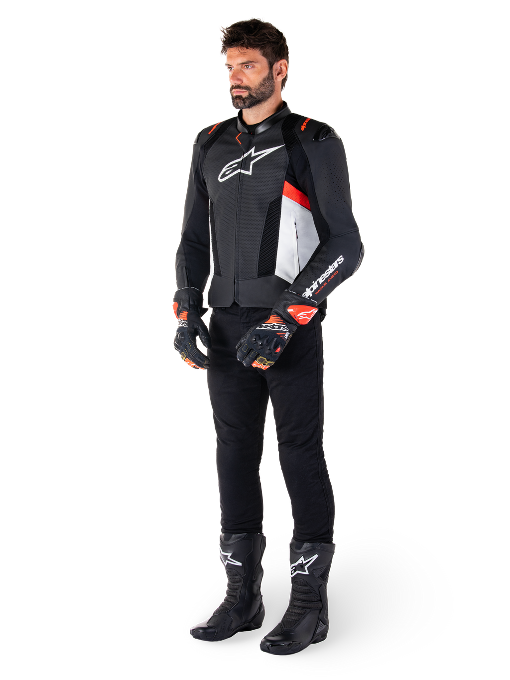 Alpinestars Missile V3 Airflow Lederjacke, Schwarz Weiß Rot Fluo, getragen von einem männlichen Model mit schwarzer Hose, schwarzen Rennhandschuhen und schwarzen Stiefeln, mit perforiertem Leder für Belüftung, weißem Brustlogo und fluoreszierenden roten Akzenten, entwickelt für erstklassige Renn- und Sport-Performance.