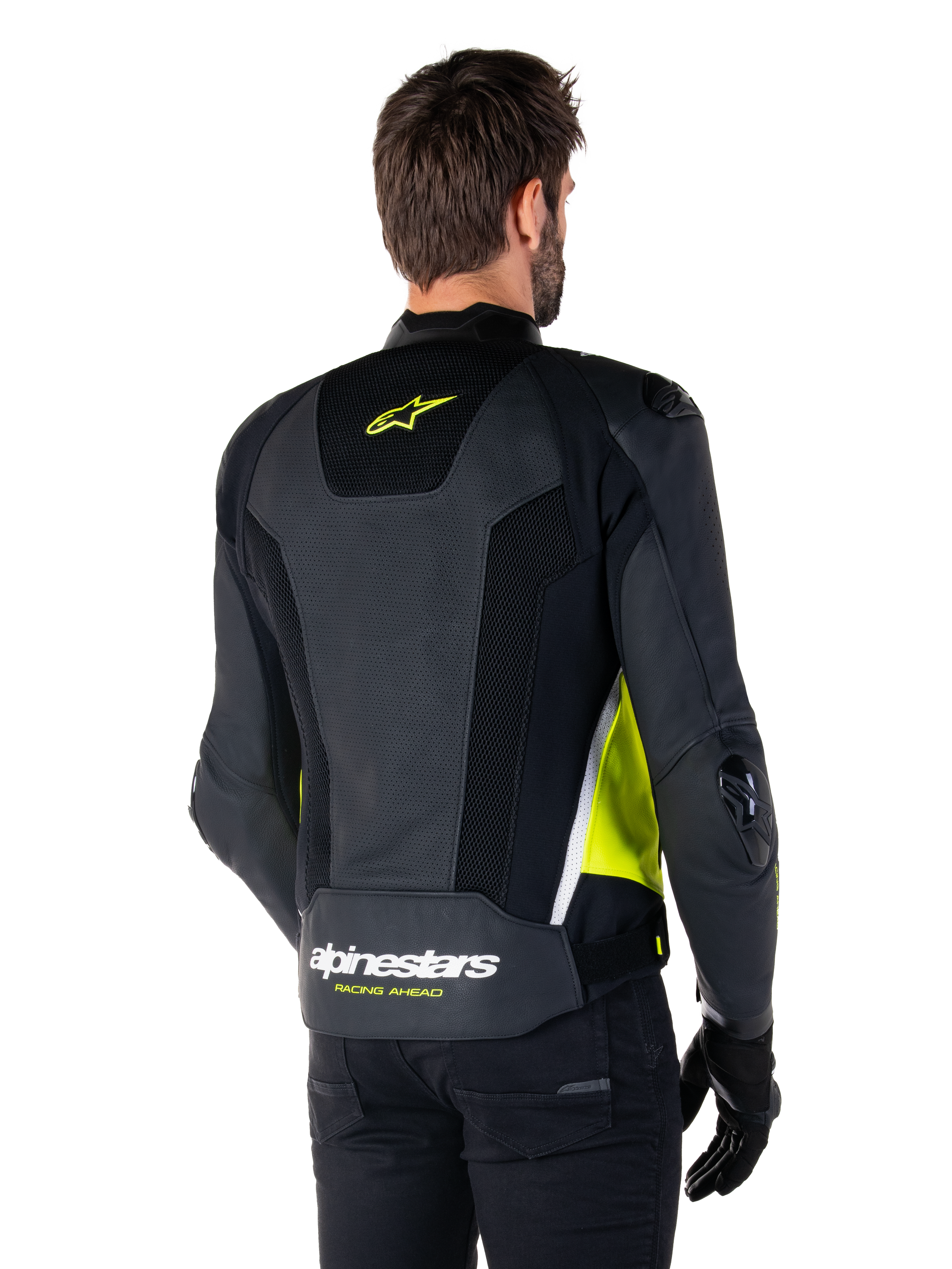 Alpinestars Missile V3 Airflow Lederjacke, Rückansicht an einem männlichen Modell, Schwarz mit neongelben und weißen Akzenten, großflächige perforierte Leder- und Mesh-Einsätze am Rücken, gelbes Stern-Logo und weißer „RACING AHEAD“-Schriftzug, kombiniert mit schwarzen Handschuhen und einer schwarzen Hose.