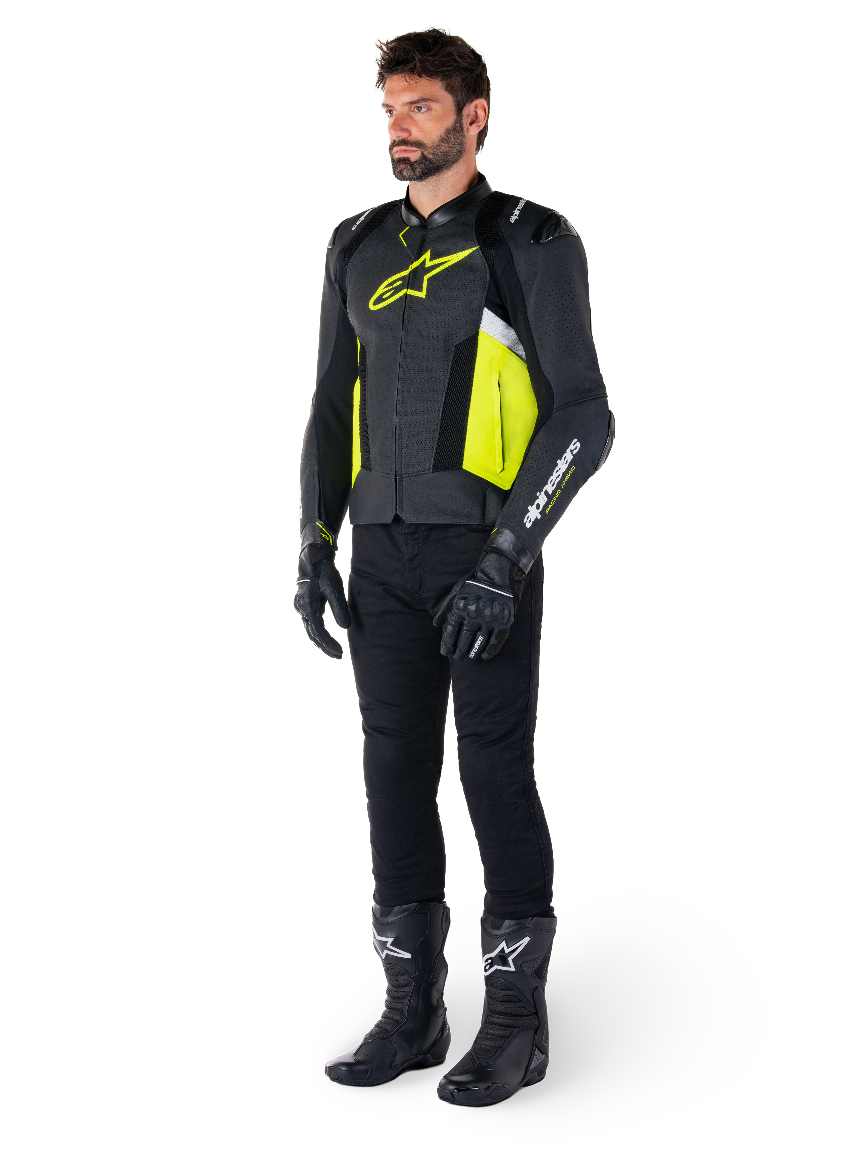 Männliches Model in der Alpinestars Missile V3 Airflow Lederjacke in Schwarz, Gelb Fluo und Weiß, kombiniert mit schwarzen Motorradhandschuhen, Hose und Stiefeln, zeigt das perforierte Lederdesign und die vom Rennsport inspirierte Ästhetik.