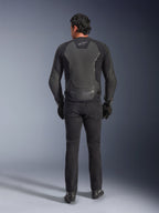 Veste en cuir Alpinestars GP Force V2, noir, vue de dos, veste de moto sportive premium avec construction cuir-textile, portée avec un jean de moto noir et des gants, dotée de panneaux de protection aux épaules et de détails de la marque