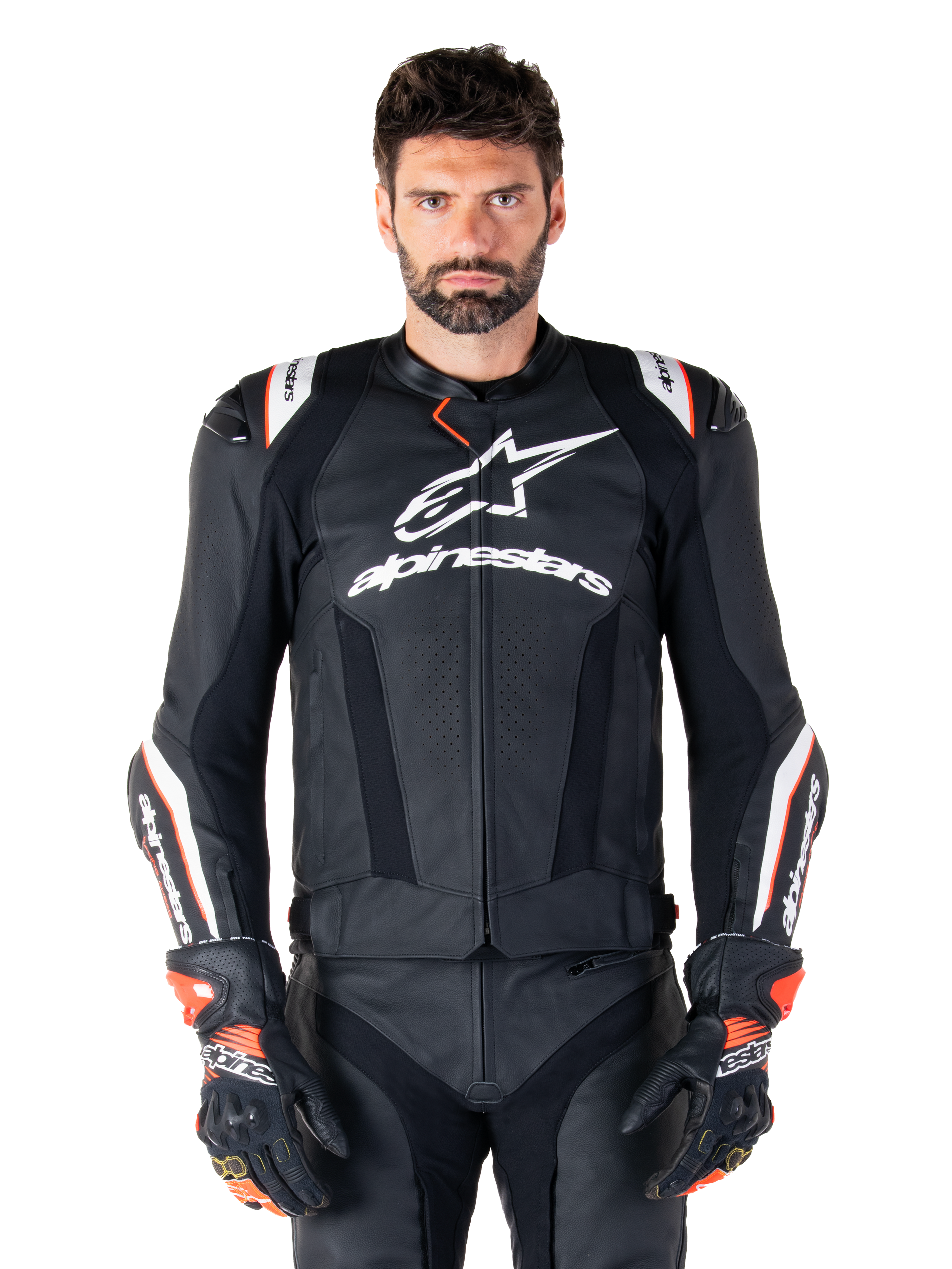 Alpinestars Missile V3 Ignition Lederjacke, Schwarz mit weißen und roten Akzenten, getragen von einem männlichen Model mit passenden Rennhandschuhen und -hose, aus der MotoGP abgeleitete Sport-Motorradjacke mit markantem Branding