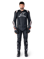 Männlicher Motorradfahrer in der Alpinestars Missile V3 Ignition Lederjacke in Schwarz, kombiniert mit passender Lederhose, Handschuhen und Stiefeln, mit weißem Alpinestars-Branding und roten Akzenten, entwickelt für professionelle Rennsportleistung.
